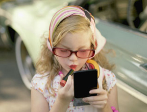 Young girl applying lipstick --- Image by © Angela Coppola/Solus-Veer/Corbis